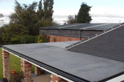 Flat roof connected to shingle roof
